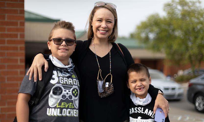 A mother and students smile